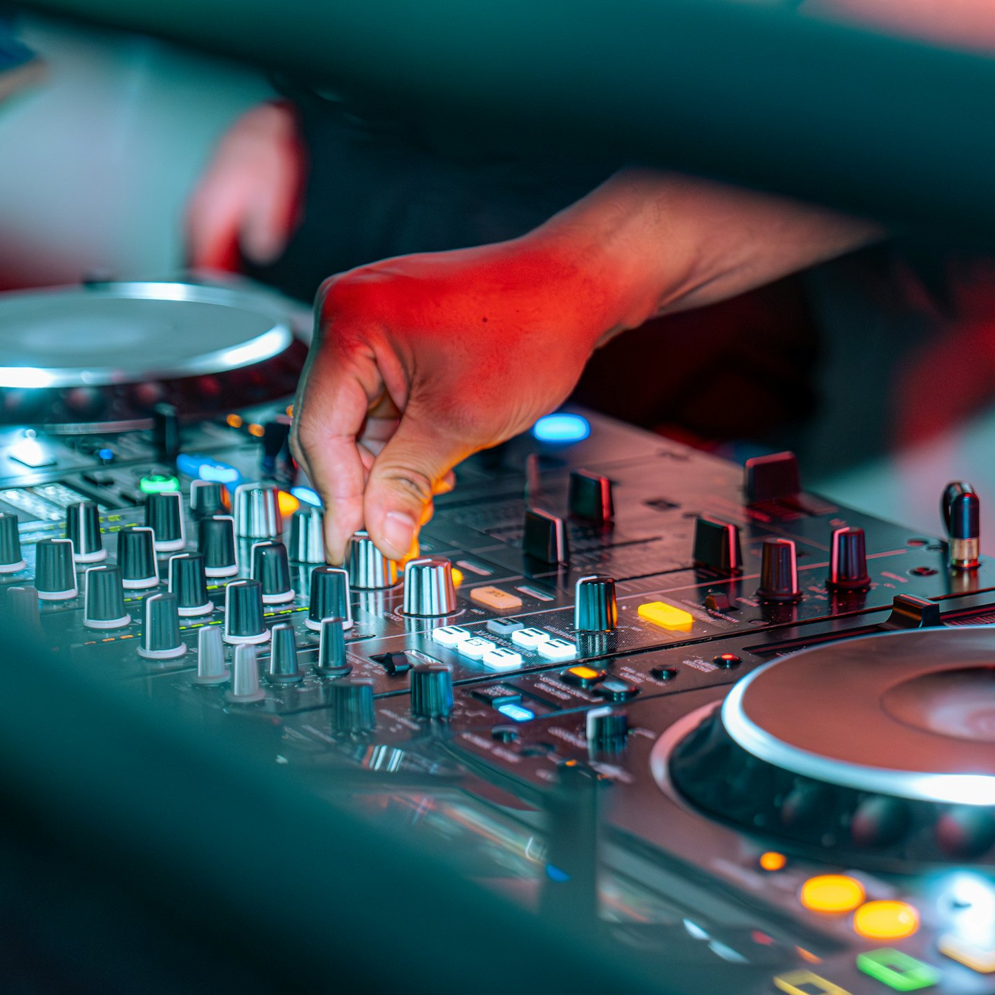 A hand adjusts a knob on a professional sound mixer.
